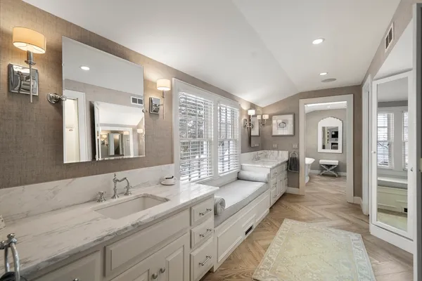 a spacious bathroom with a double vanity sink a mirror and a shower