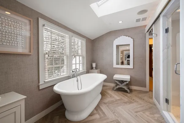 a white bath tub sitting in a bathroom next to a window