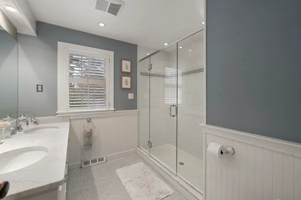 a bathroom with a shower sink and mirror