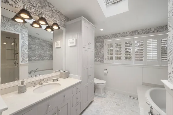 a bathroom with a double vanity sink toilet and a mirror