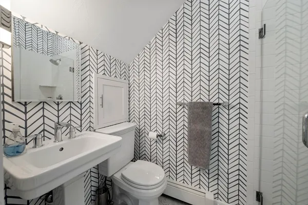 a bathroom with a sink and mirror with toilet