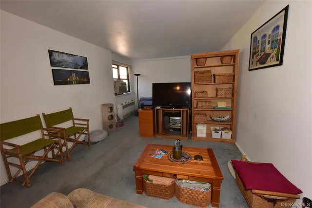 a living room with furniture a flat screen tv and kitchen view