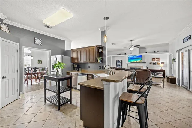 a kitchen with stainless steel appliances kitchen island granite countertop a table chairs and a refrigerator