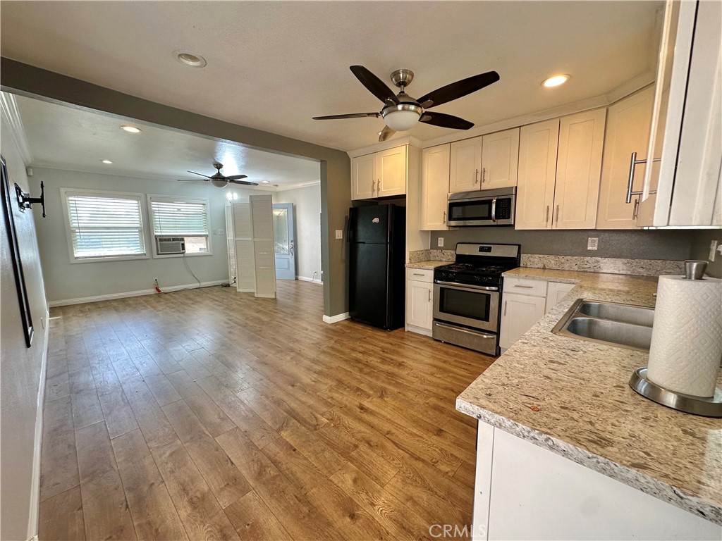 441 Hurstview Avenue Monrovia, CA 91016 - Photo 11 of 16 a kitchen with stainless steel appliances granite countertop a sink a stove top oven a refrigerator with wooden floors