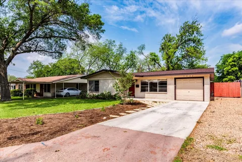 a front view of a house with a yard and trees