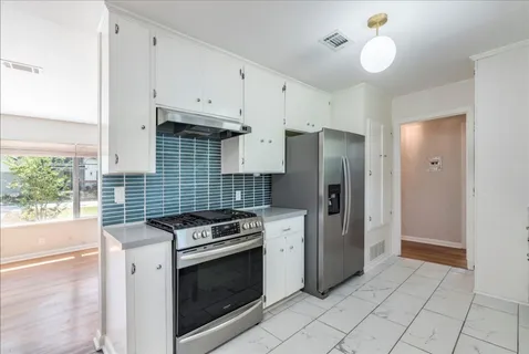 a kitchen with stainless steel appliances granite countertop a stove and a refrigerator
