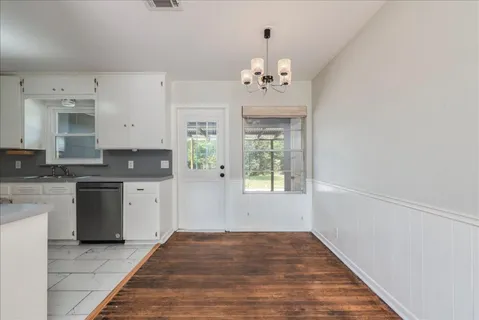 a view of kitchen with granite countertop stove top oven and cabinets