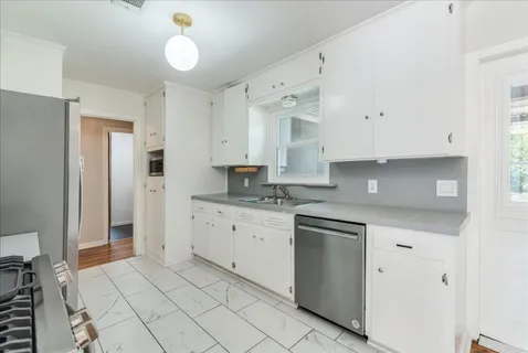 a kitchen with granite countertop white cabinets and white appliances