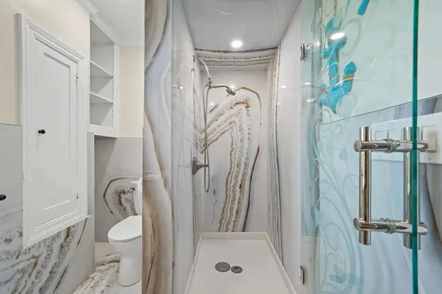 a bathroom with a granite countertop sink toilet and shower