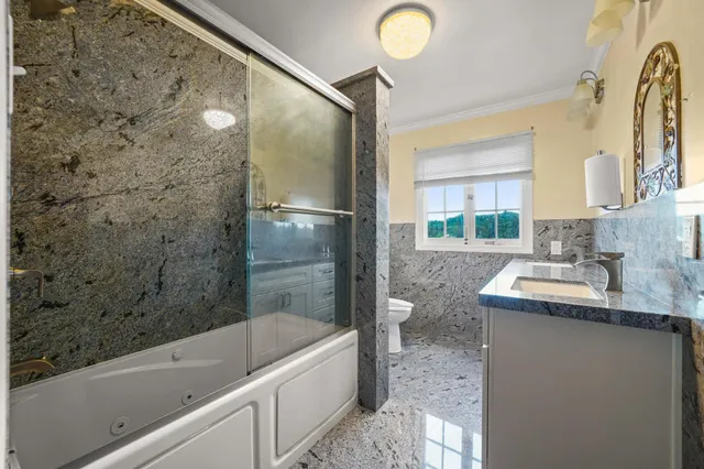 a bathroom with a granite countertop sink a toilet and bathtub