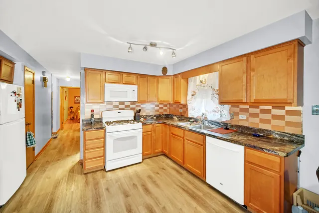 a kitchen with stainless steel appliances granite countertop sink stove and refrigerator