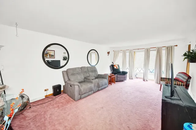 a living room with furniture a large window and a chandelier