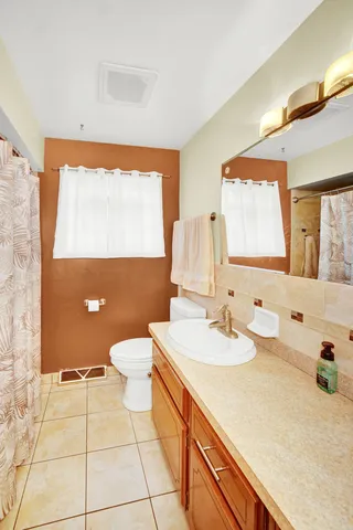 a bathroom with a toilet sink and mirror