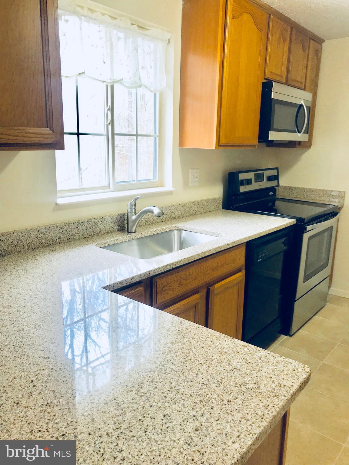 6214 Hillside Road Springfield, VA 22152 - Photo 5 of 22 a kitchen with stainless steel appliances granite countertop a sink stove and microwave