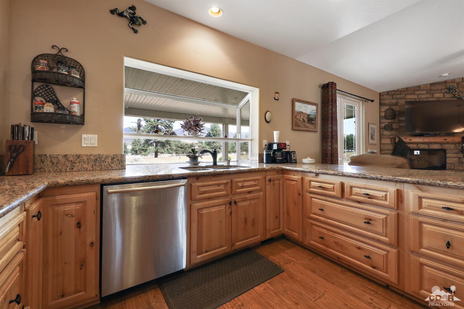 59870 Devils Ladder Road Mountain Center, CA 92561 - Photo 11 of 31 a kitchen with granite countertop white cabinets and stainless steel appliances