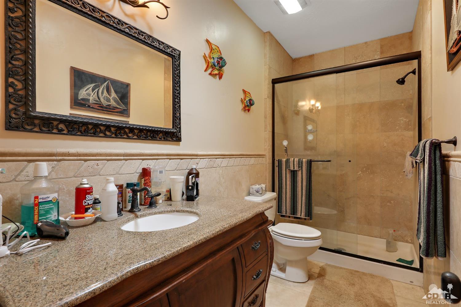 59870 Devils Ladder Road Mountain Center, CA 92561 - Photo 15 of 31 a bathroom with a granite countertop sink mirror vanity and toilet