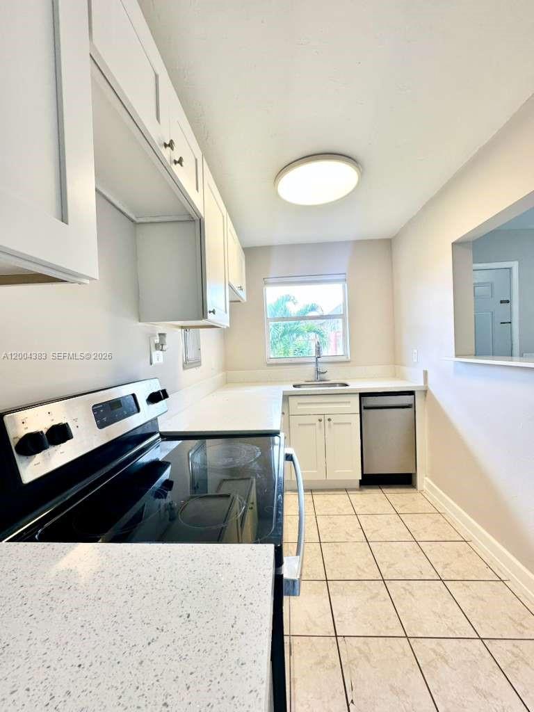 2651 Northwest 13th Street, Unit 41 Miami, FL 33125 - Photo 4 of 10 a kitchen with a stove a sink and a refrigerator
