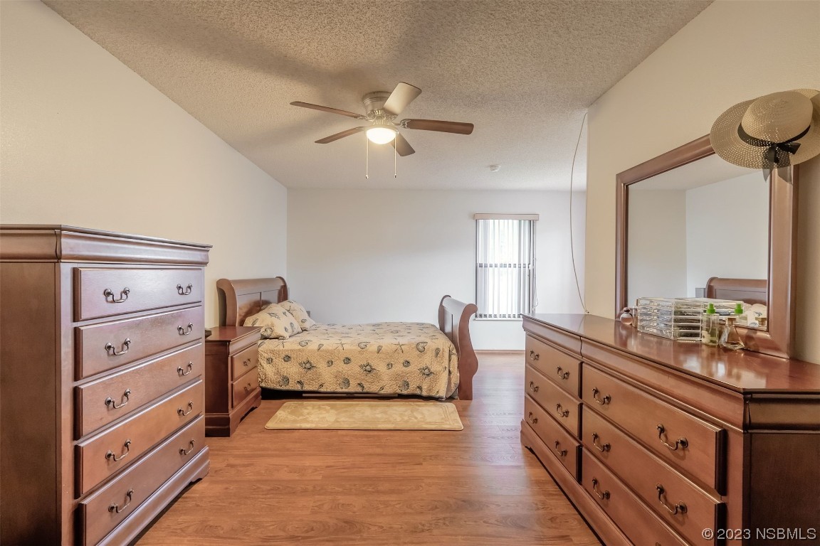 2804 Mango Tree Drive Edgewater, FL 32141 - Photo 11 of 29 a spacious bedroom with a bed and a chandelier