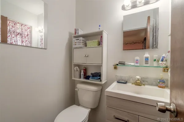 a bathroom with a toilet a sink and mirror