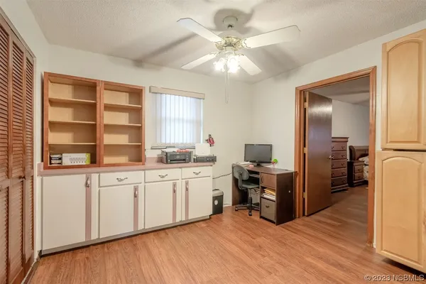 a view of a hallway with wooden floor and furniture