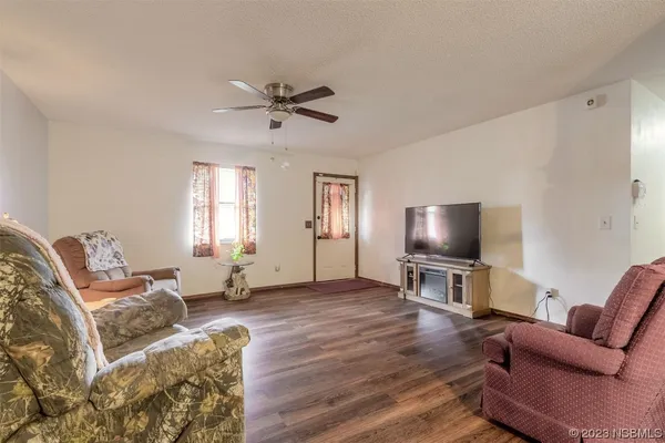a living room with furniture a window and a flat screen tv