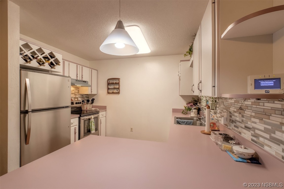 2804 Mango Tree Drive Edgewater, FL 32141 - Photo 7 of 29 a kitchen with granite countertop a refrigerator and a stove