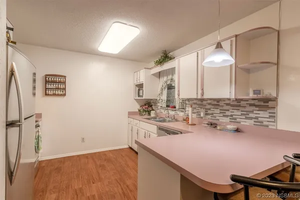 a kitchen with a sink cabinets and wooden floor