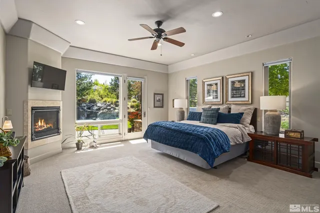 a spacious bedroom with a bed a ceiling fan and a couch