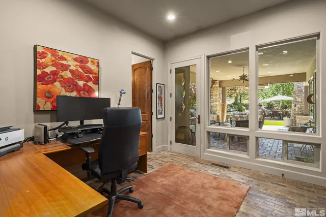 a view of a workspace with furniture and a window