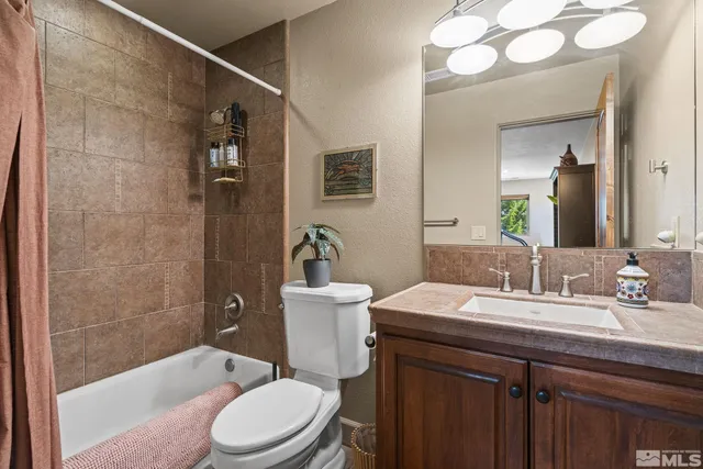 a bathroom with a sink a toilet a mirror and shower