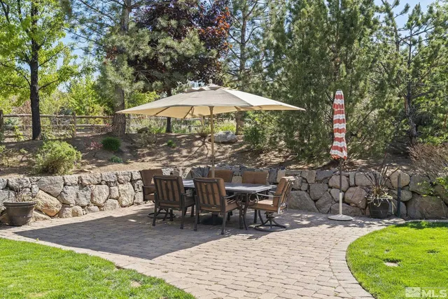 a view of a patio with a table and chairs under an umbrella