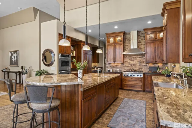 a kitchen with stainless steel appliances granite countertop a sink a stove and a refrigerator