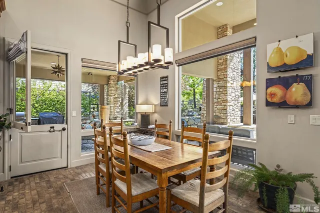 a dining room with furniture and large windows