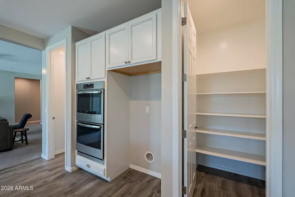 a kitchen that has a lot of cabinets a sink and wooden floor