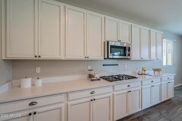 a kitchen with stainless steel appliances granite countertop a sink a stove a dining table and chairs