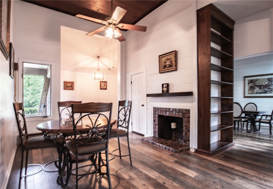200 Chenault Road Townville, SC 29689 - Photo 11 of 47 Rich hardwood flooring complements a cozy fireplace, creating an inviting dining atmosphere.