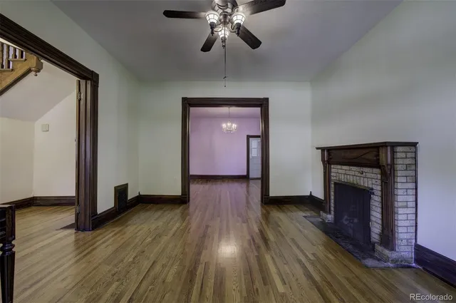 a view of empty room with wooden floor and fireplace