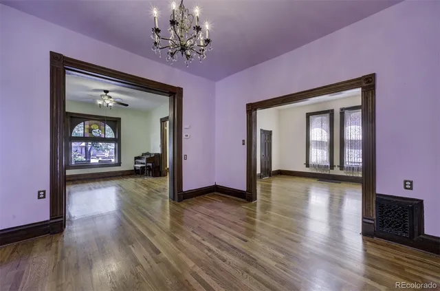 a view of a livingroom with wooden floor and a chandelier