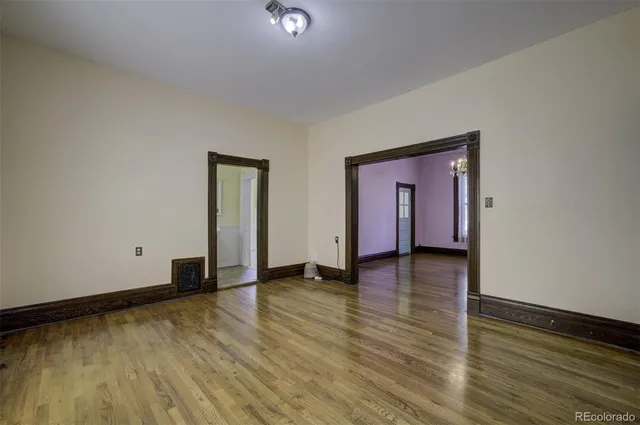 a view of empty room with wooden floor and window