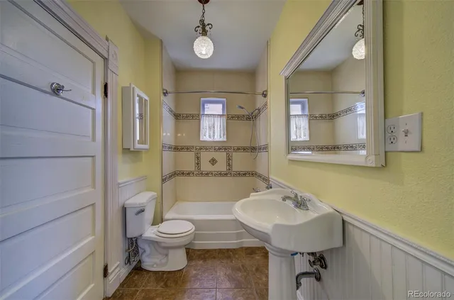 a bathroom with a toilet a sink and mirror
