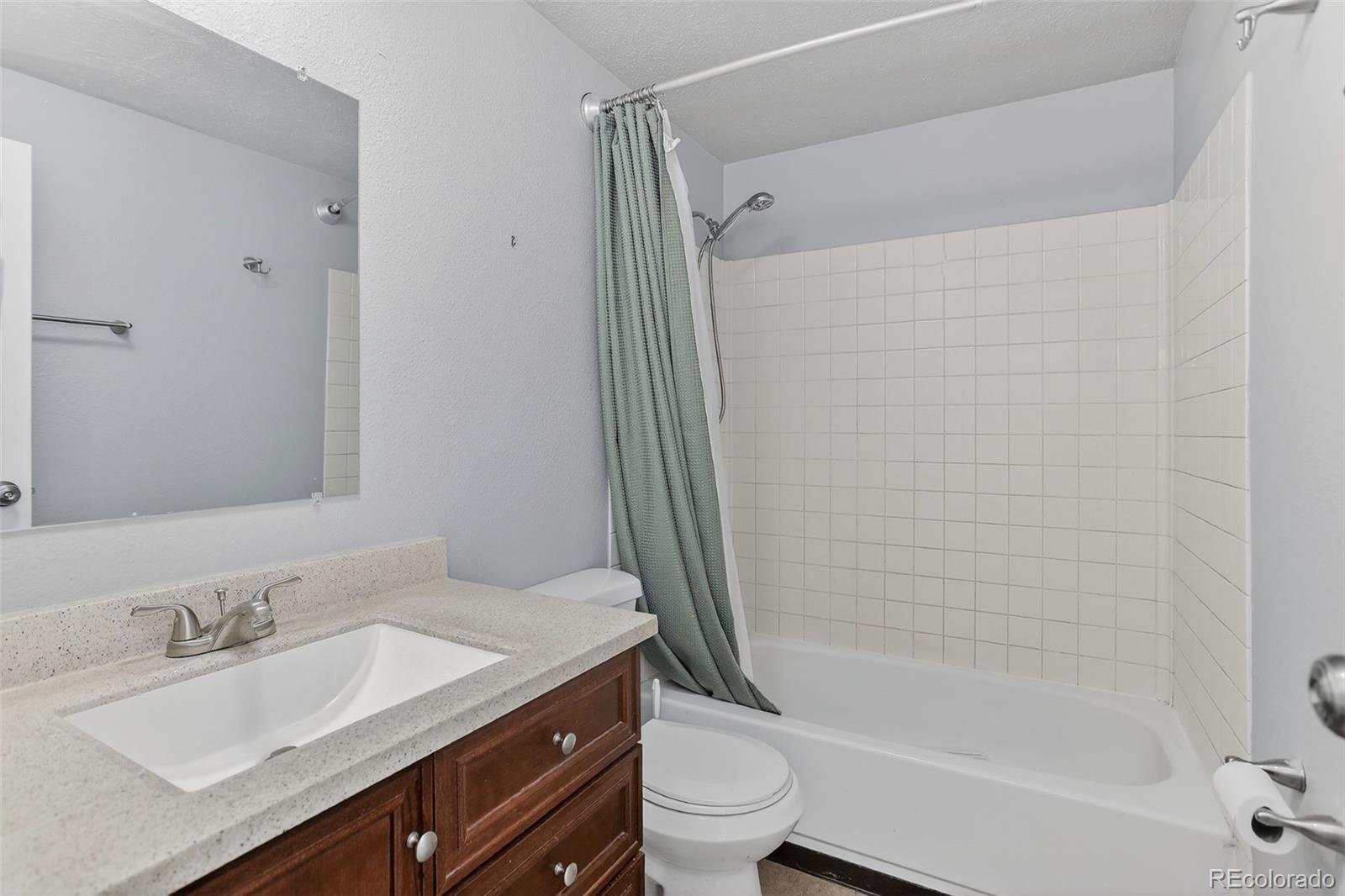 9404 Pierce Street Broomfield, CO 80021 - Photo 12 of 20 a bathroom with a granite countertop sink toilet and shower