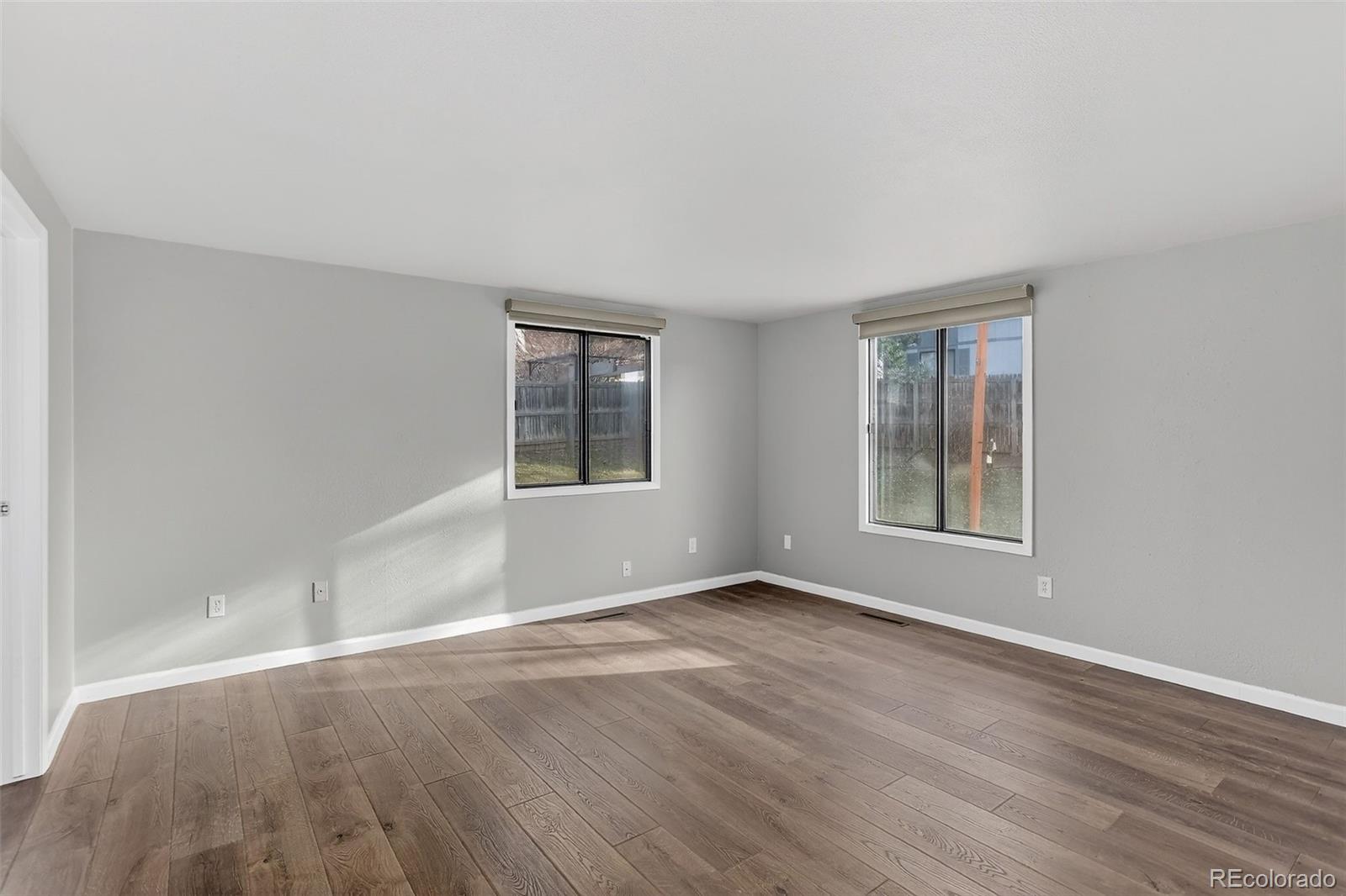 9404 Pierce Street Broomfield, CO 80021 - Photo 5 of 20 an empty room with wooden floor and windows