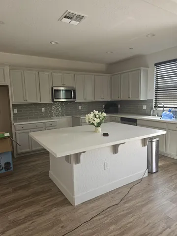 a white kitchen with a sink and cabinets
