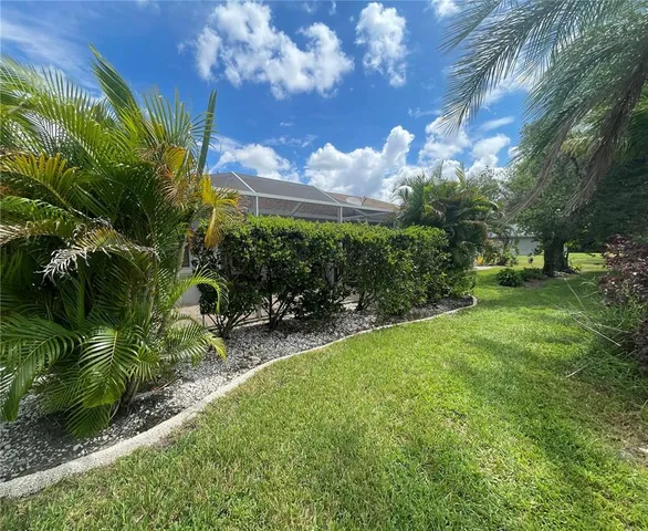 a view of a yard with plants and a fountain