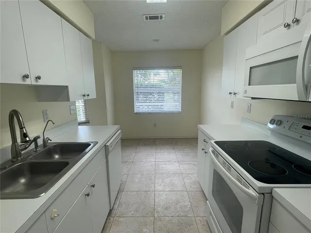 a kitchen with a sink stove top oven and cabinets