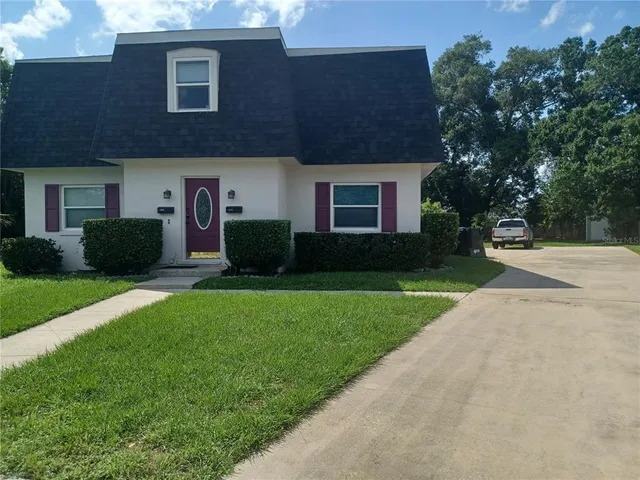 a front view of a house with a garden and yard