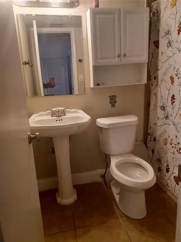 a bathroom with a toilet a sink and mirror