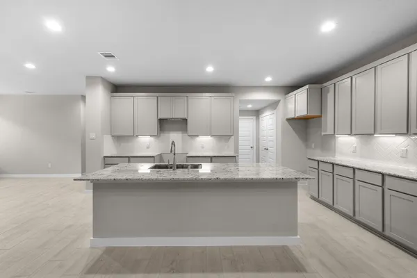 a large kitchen with stainless steel appliances granite countertop a sink a stove and a refrigerator
