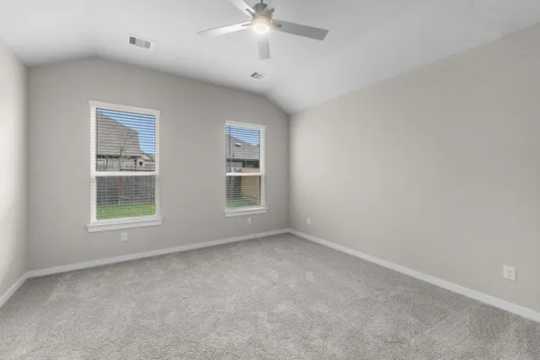 an empty room with windows and fan