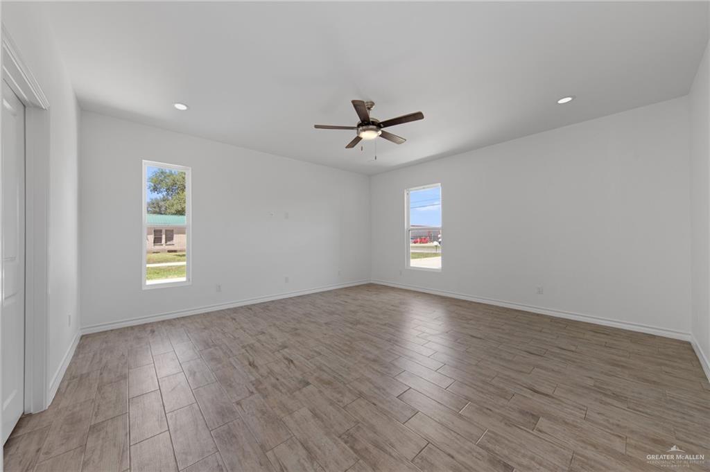 15688 Primera Road Harlingen, TX 78552 - Photo 14 of 20 an empty room with wooden floor and windows